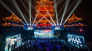 Chinese and foreign media delegates attend a illuminated cultural and smart manufacturing light show in front of a illuminated traditional pagoda stage in Wuhan, China.
