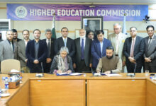 Representatives from HEC Pakistan and National CERT signing an MoU at a conference table, surrounded by senior officials under a Higher Education Commission banner.