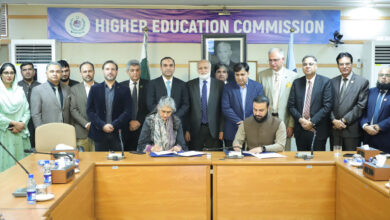 Representatives from HEC Pakistan and National CERT signing an MoU at a conference table, surrounded by senior officials under a Higher Education Commission banner.